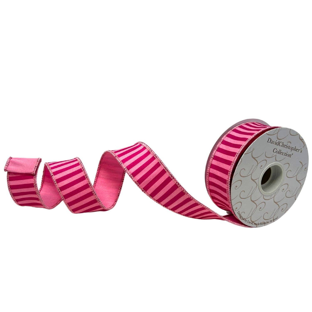 Roll of pink striped ribbon with a decorative spool on a white background