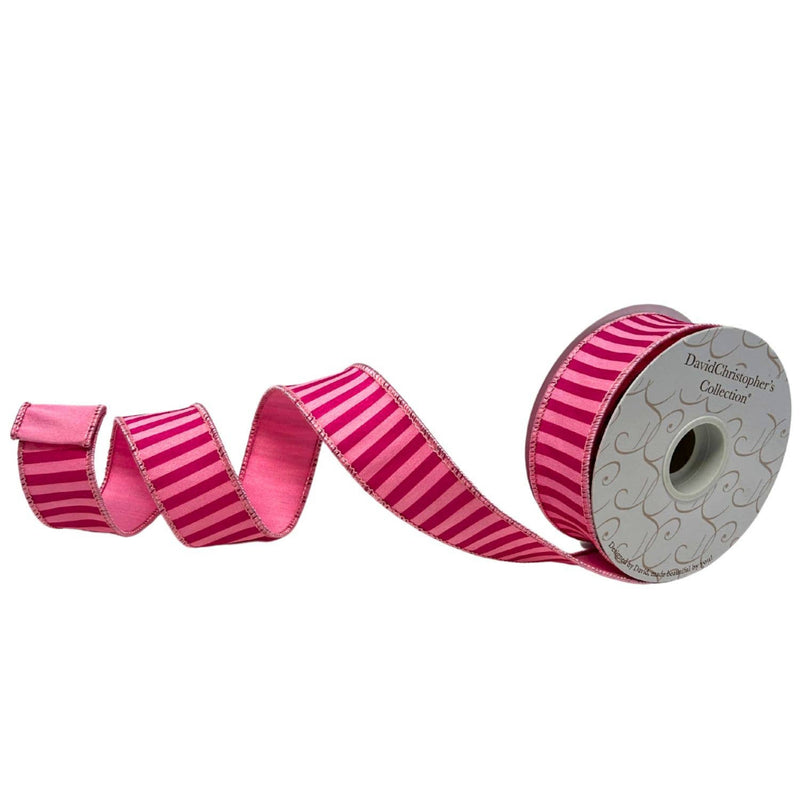 Roll of pink striped ribbon with a decorative spool on a white background