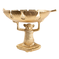 A gold-colored decorative bowl featuring a monkey figure.