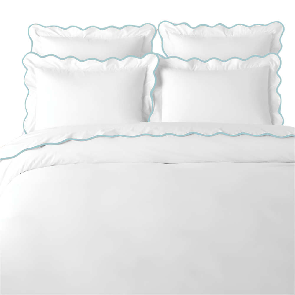 White bedding set with blue scalloped edges on a white background