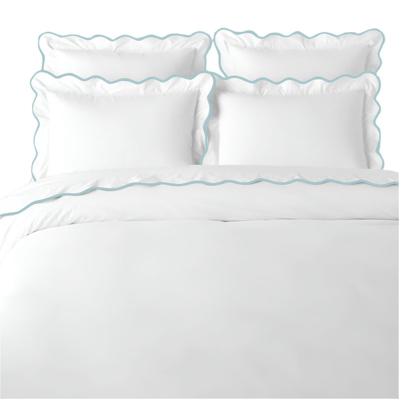 White bedding set with blue scalloped edges on a white background