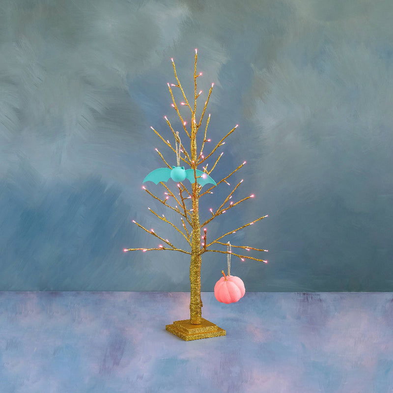 Decorative tree with lights and ornaments against a textured blue background